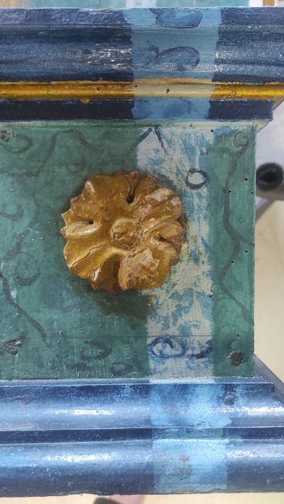 Fragment ołtarzyka ukazujący odkrywkę pasową z czytelną, dobrze zachowaną oryginalną warstwą marmoryzacji tj. imitacji marmuru wykonanej w technice malarskiej na drewnianej strukturze. Fot. ze zbior&oacute;w autorki